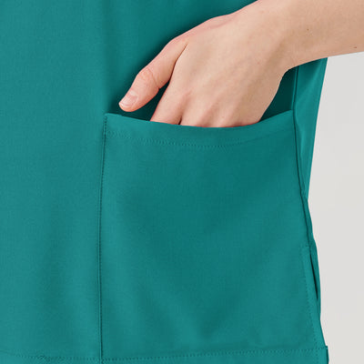 Uniforme médico de mujer verde esmeralda con bolsillos grandes.
