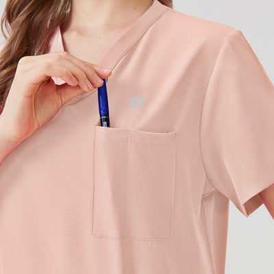 Uniforme médico rosa para mujer con bolsillos multifunción.