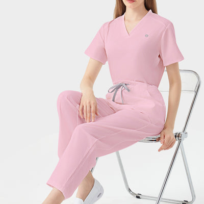 Bata quirúrgica rosa de mujer, modelo sentada para demostración