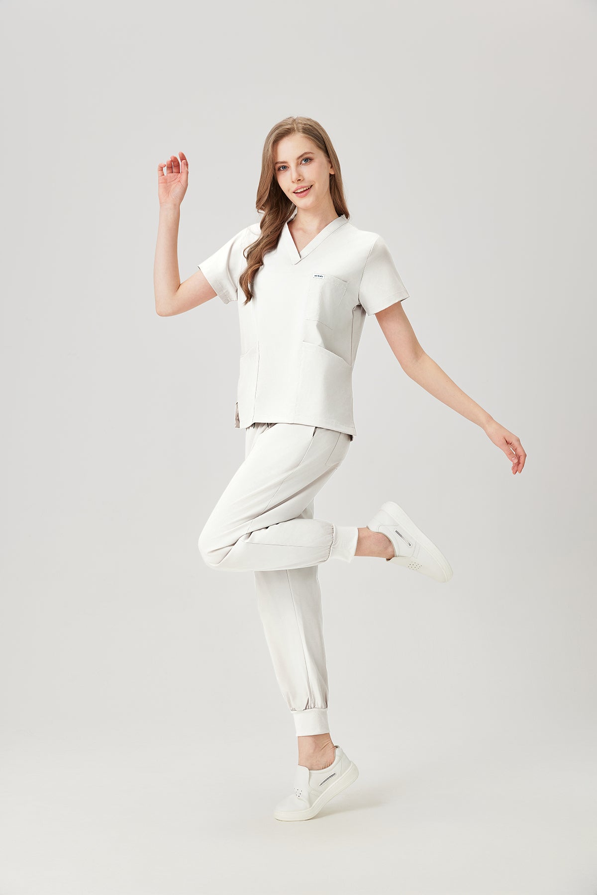 Uniforme médico quirúrgico de color blanco crema para mujer, vista lateral