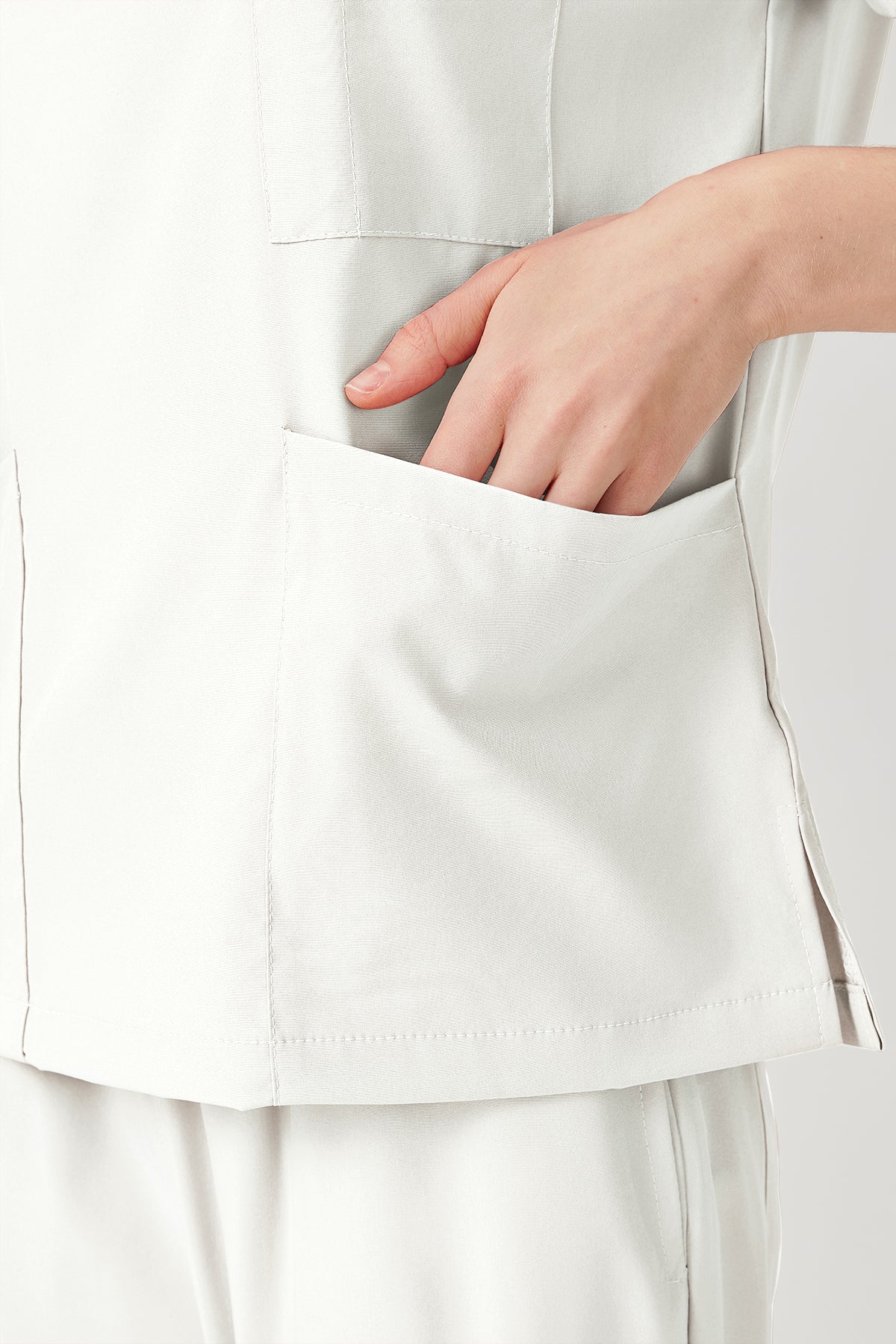 Uniforme médico quirúrgico blanco para mujer con bolsillos grandes.