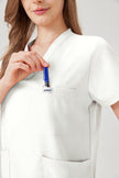 Uniforme médico quirúrgico blanco para mujer con bolsillos en el pecho.