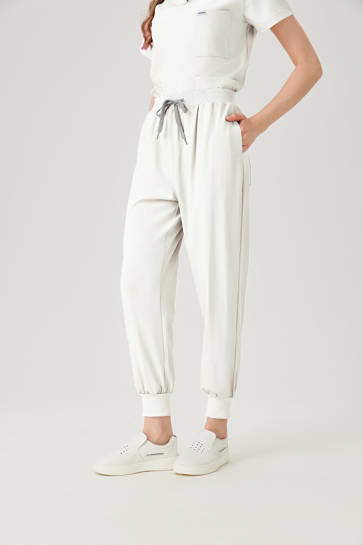 Uniforme médico quirúrgico blanco de mujer, vista frontal del pantalón