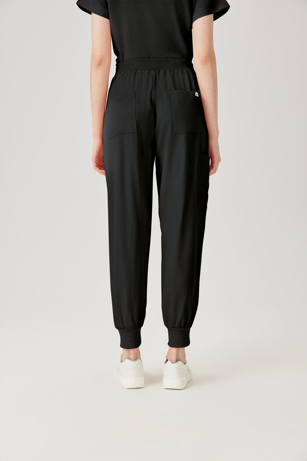 Bata quirúrgica negra JelriSoFit® para mujer, vista posterior del pantalón