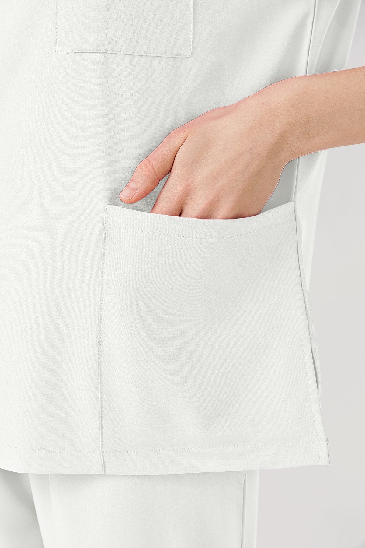Ropa de trabajo blanca para mujer con bolsillos grandes.