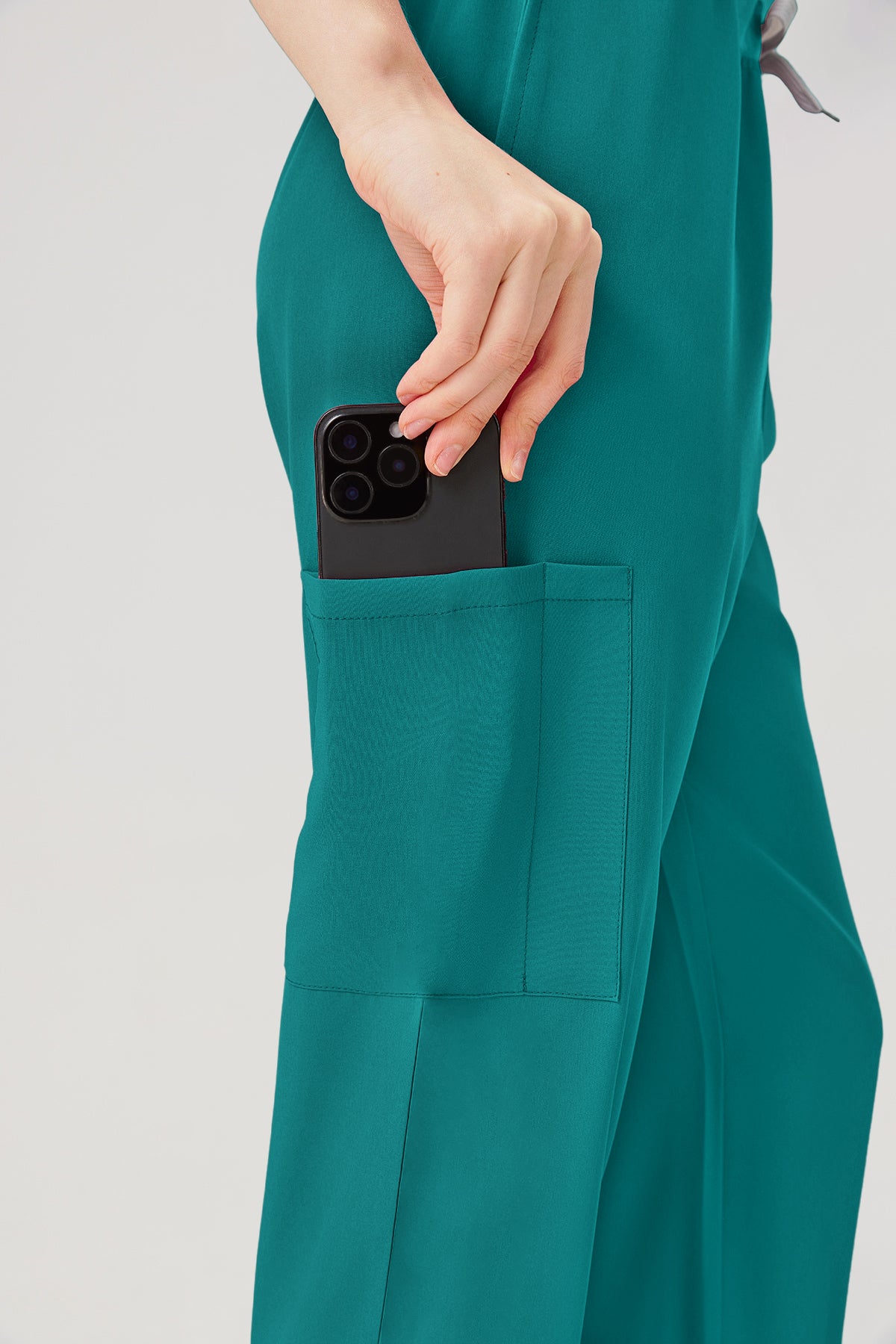 Uniforme médico femenino verde esmeralda, detalle de los bolsillos del pantalón.