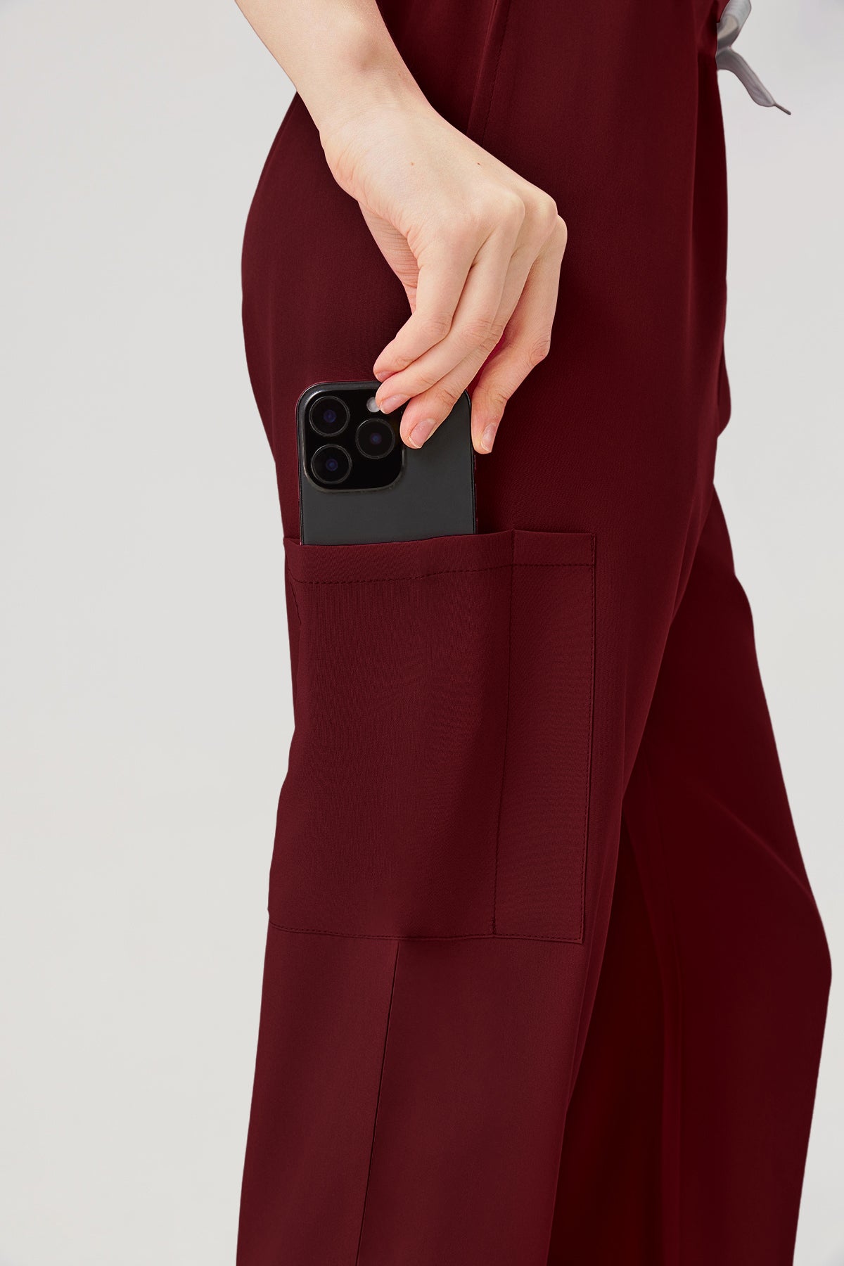 Bata quirúrgica burdeos para mujer con grandes bolsillos en los pantalones.