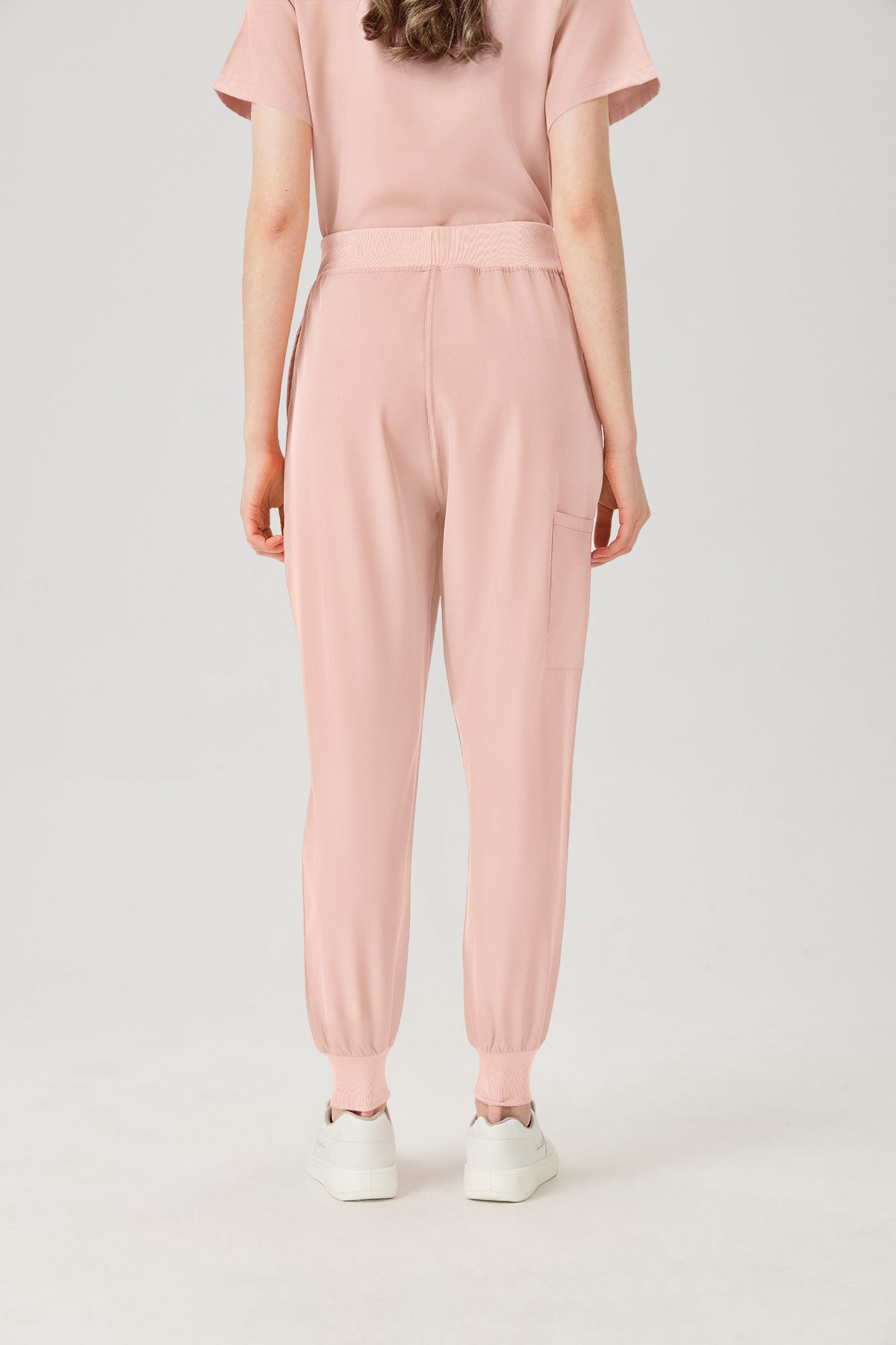 Vista posterior de los pantalones del uniforme médico de mujer de color rosa.