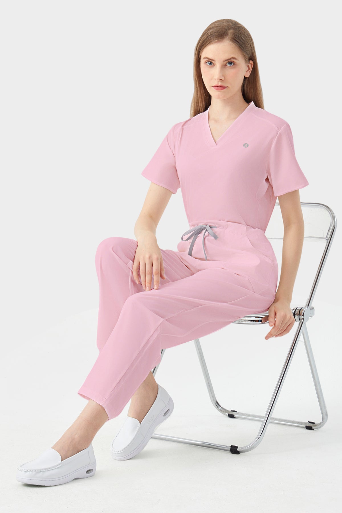 Bata quirúrgica rosa de mujer, modelo sentada para demostración